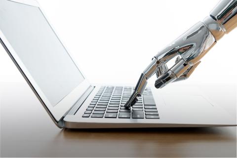 Robot typing on laptop keyboard