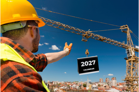 Construction worker directs crane carrying a calendar