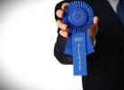 Hand holding blue ribbon